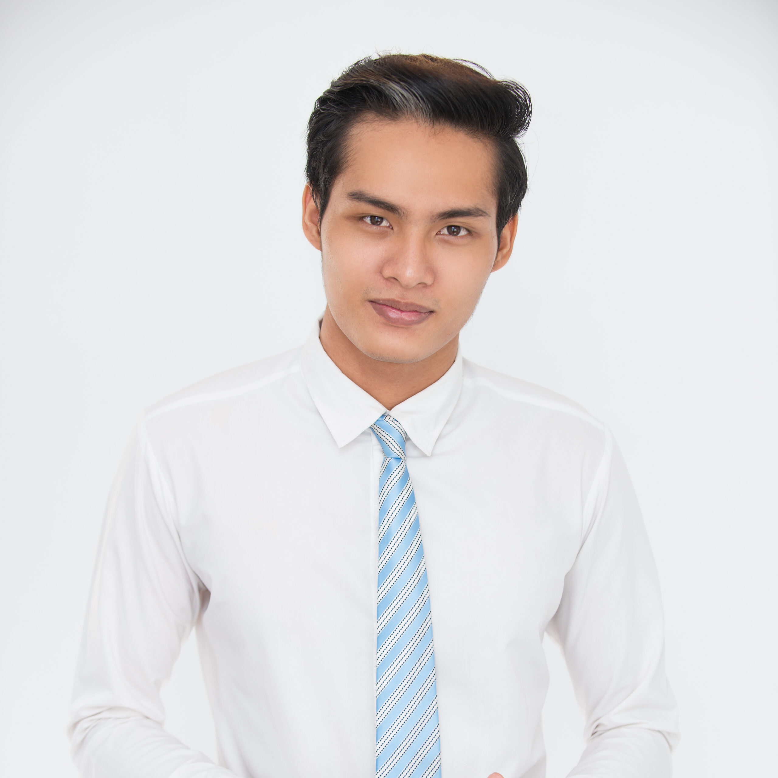 Portrait of confident young Asian businessman wearing shirt and tie holding touchpad and looking at camera